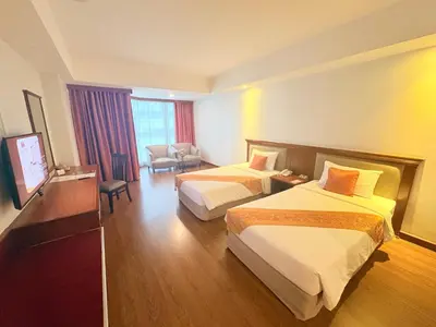 a hotel room with two beds and a television at Tai Pan Hotel in Bangkok