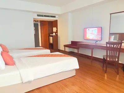 a bedroom with two beds and a desk with a computer at Tai Pan Hotel in Bangkok