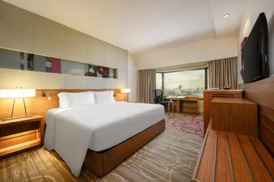 a hotel room with a bed and a television at Centara Grand at Central Plaza Ladprao Bangkok in Bangkok