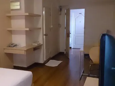 a room with a bed and a desk and a door at The Blooms Residence in Bangkok