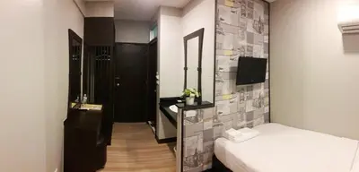 a small room with two beds and a mirror at YWCA Hotel Bangkok in Bangkok