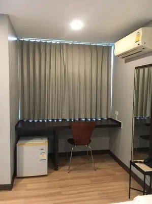 a desk in a room with a curtain and a chair at YWCA Hotel Bangkok in Bangkok