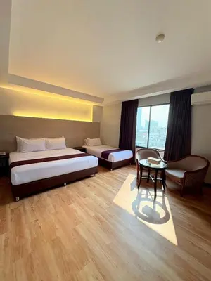 a hotel room with a bed and a table at Atrium Boutique Hotel in Bangkok