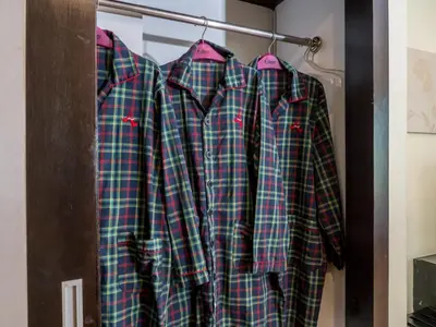 four pajamas hanging on a rack in a closet at Atrium Boutique Hotel in Bangkok