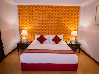 a hotel room with a large bed with two tables at Atrium Boutique Hotel in Bangkok