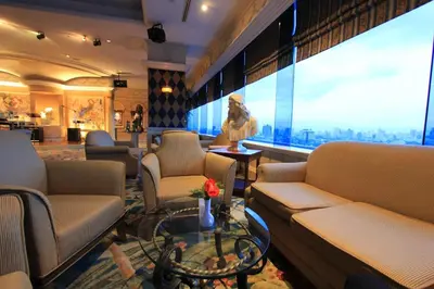 a waiting room with couches and a large window at Golden Tulip Sovereign Hotel Bangkok in Bangkok