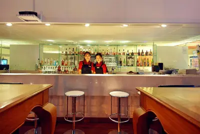 two women standing behind a bar in a restaurant at Le Fenix Sukhumvit 11 Bangkok in Bangkok