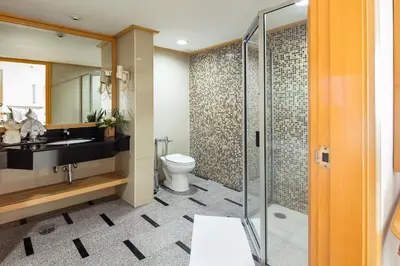 a bathroom with a toilet and a glass shower at Baiyoke Sky Hotel in Bangkok