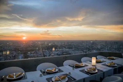 a table with chairs and a view of a city at Baiyoke Sky Hotel in Bangkok