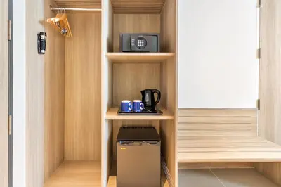 a small kitchen with a coffee maker on a shelf at Holiday Inn Express Bangkok Soi Soonvijai by IHG in Bangkok