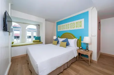 a bedroom with a large bed with a blue headboard at La Petite Salil Sukhumvit 8 in Bangkok
