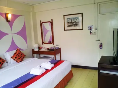 a hotel room with a bed and a mirror at Sawasdee Sukhumvit Inn in Bangkok