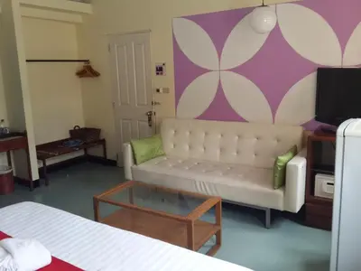 a living room with a couch and a tv at Sawasdee Sukhumvit Inn in Bangkok