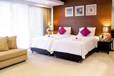 a bedroom with two beds with white and purple pillows at FuramaXclusive Sathorn, Bangkok in Bangkok