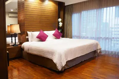a bedroom with a large bed with pink pillows at FuramaXclusive Sathorn, Bangkok in Bangkok
