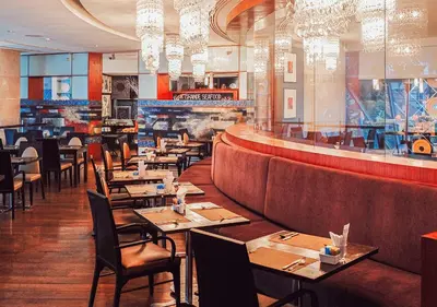 a restaurant with tables and chairs and a bar at Hilton Bangkok Grande Asoke in Bangkok