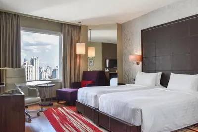 a hotel room with a large bed and a desk at Hilton Bangkok Grande Asoke in Bangkok
