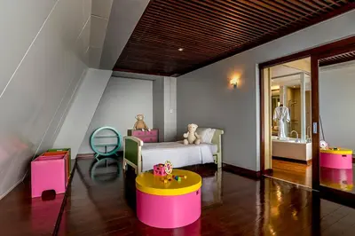 a bedroom with a bed and a table and a chair at Hilton Bangkok Grande Asoke in Bangkok
