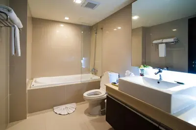 a bathroom with a sink and a toilet and a tub at Aspen Suites Hotel Sukhumvit 2 in Bangkok
