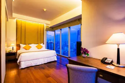 a bedroom with a bed and a desk with a phone at Column Bangkok Hotel in Bangkok