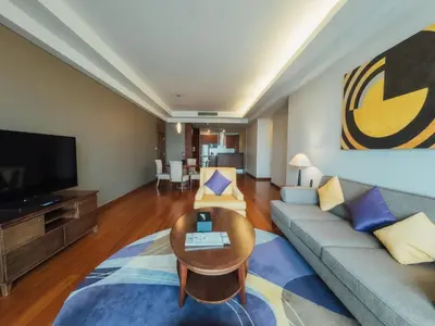 a living room with a couch and a tv at Column Bangkok Hotel in Bangkok
