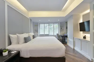 a bedroom with a large white bed and a desk at Centre Point Sukhumvit Thong-Lo in Bangkok