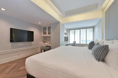 a bedroom with a large bed and a flat screen tv at Centre Point Sukhumvit Thong-Lo in Bangkok