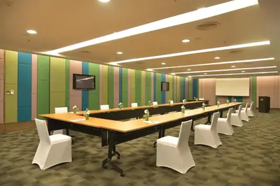 a large conference room with a long table and white chairs at Rama Gardens Hotel Bangkok in Bangkok