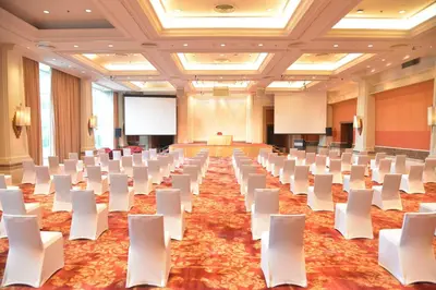 a conference room with white chairs and a podium at Rama Gardens Hotel Bangkok in Bangkok