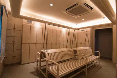 a dressing room with a bench and some lockers at Rama Gardens Hotel Bangkok in Bangkok