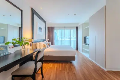 a bedroom with a bed and a desk and a desk at Somerset Park Suanplu Bangkok in Bangkok