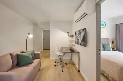 a room with a bed and a couch and a desk at Citadines Sukhumvit 16 Bangkok in Bangkok