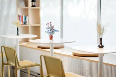 a room with two tables with chairs and a vase of flowers at Citadines Sukhumvit 16 Bangkok in Bangkok