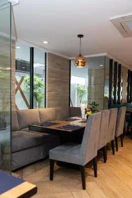 a dining room with a couch and a table and chairs at Club Mahindra Mac Boutique Hotel in Bangkok