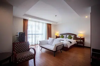 a bedroom with a bed and a couch and a chair at Nana Hiso Hotel in Bangkok