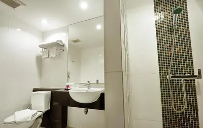 a bathroom with a sink and a toilet and a shower at Nana Hiso Hotel in Bangkok