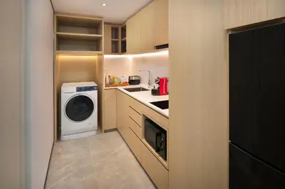 a small kitchen with a washer and dryer in it at Crowne Plaza Bangkok Lumpini Park by IHG in Bangkok