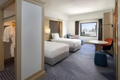 a hotel room with two beds and a table at Crowne Plaza Bangkok Lumpini Park by IHG in Bangkok