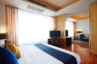 a hotel room with a bed and a television at The Duchess Hotel in Bangkok