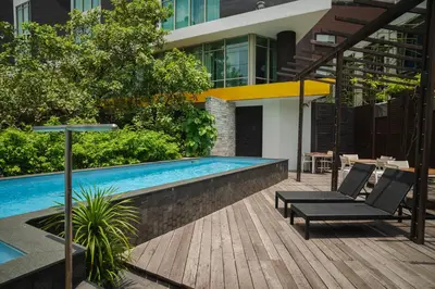 a swimming pool with two lounge chairs next to a building at TUI BLUE Maduzi Hotel Bangkok in Bangkok