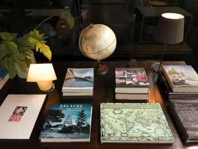 a table with books and a globe on top of it at Refillnow! Hostel in Bangkok