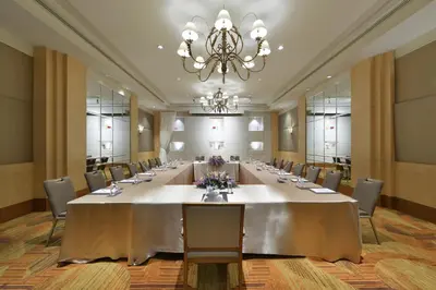 a long table in a room with chairs and a chandelier at Miracle Grand Convention Hotel in Bangkok