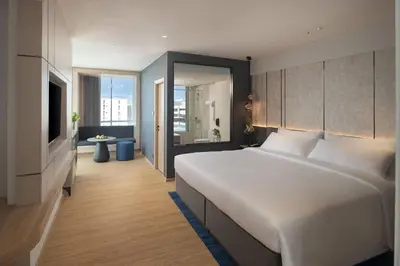 a bedroom with a large white bed and a television at Miracle Grand Convention Hotel in Bangkok