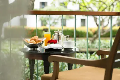 a table with a cup of coffee and a bowl of bread at The Sukhothai Bangkok in Bangkok