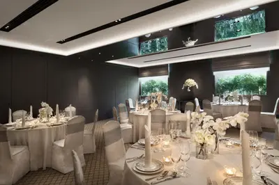 a room with white tables and chairs with white flowers at The Sukhothai Bangkok in Bangkok