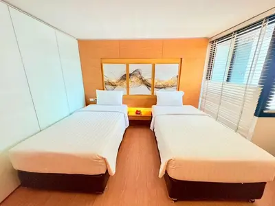 two beds in a room with two windows at I Residence Hotel Silom in Bangkok