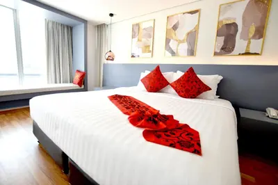 a bedroom with a large white bed with red pillows at I Residence Hotel Silom in Bangkok