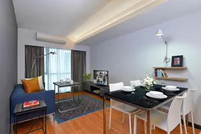 a living room with a table and a blue couch at Citadines Sukhumvit 11 Bangkok in Bangkok