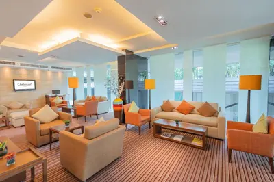 a living room with couches and chairs and tables at Oakwood Residence Sukhumvit 24 Bangkok in Bangkok