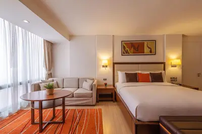 a hotel room with a bed and a couch at Oakwood Residence Sukhumvit 24 Bangkok in Bangkok